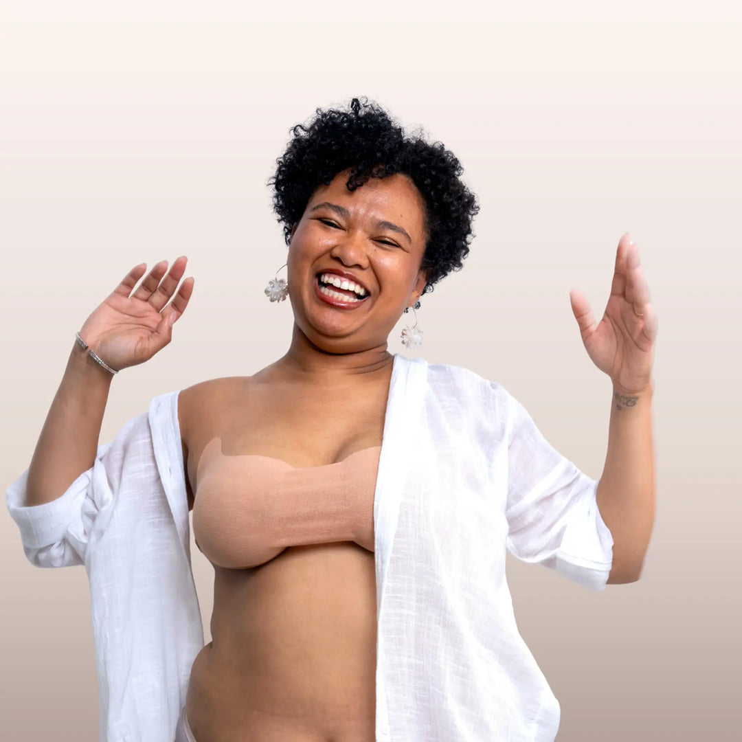 Femme métisse portant un soutien-gorge adhésif modèle Bandeau beige avec une chemise blanche entrouverte