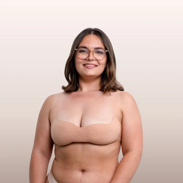 Femme à lunettes portant le soutien-gorge adhésif beige La Bande à Lolo pour un maintien naturel et invisible.
